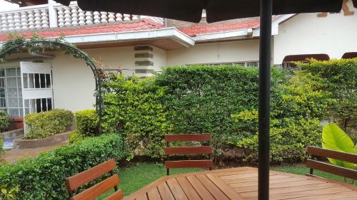 a wooden table and chairs under an umbrella at Zarita Boutique Hotel in Nairobi