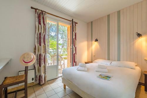 sypialnia z dużym białym łóżkiem i oknem w obiekcie Azureva Argeles w Argelès-sur-Mer