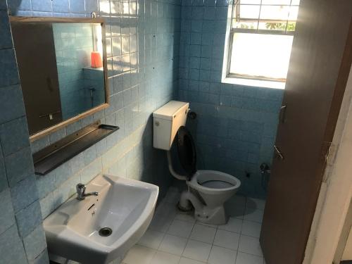 uma casa de banho com um lavatório, um WC e um espelho. em Maurya Residency em Pune