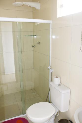 a bathroom with a toilet and a glass shower at Pousada Sol Nascente in Piranhas