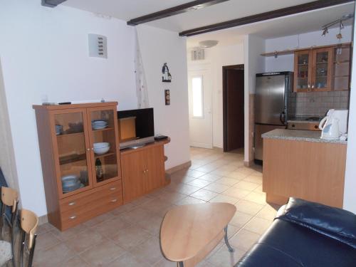 a kitchen with wooden cabinets and a counter top at Apartments Febsis in Novalja