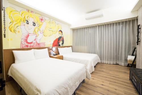 2 letti in una camera con un dipinto sul muro di Peach blossom B&B a Città di Taitung