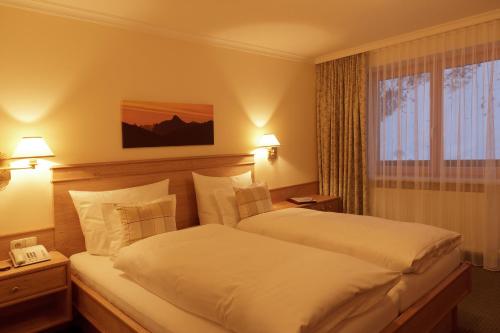 um quarto de hotel com uma cama e uma janela em Pension Gallus em Lech am Arlberg