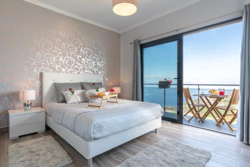 a bedroom with a large bed and a balcony at Casa das Abertas in Calheta