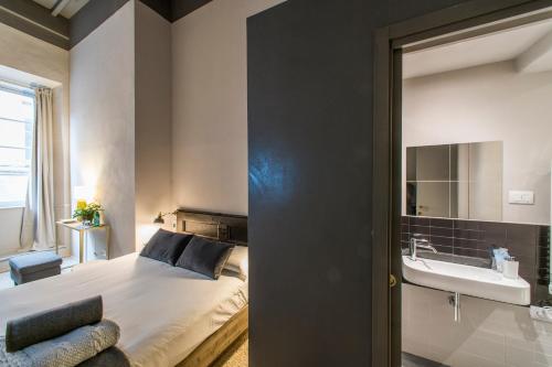 a bedroom with a bed and a sink and a bathroom at Palazzo del Papa in Siena
