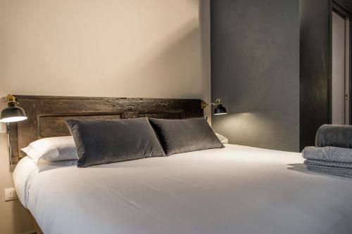a bedroom with a white bed with a wooden headboard at Palazzo del Papa in Siena