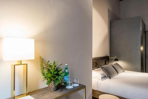 a bedroom with a bed and a table with a lamp at Palazzo del Papa in Siena