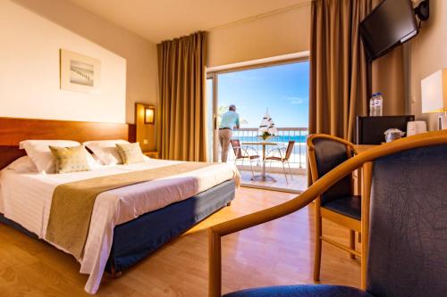a hotel room with a bed and a view of the ocean at Hôtel Restaurant Splendid Camargue in Le Grau-du-Roi