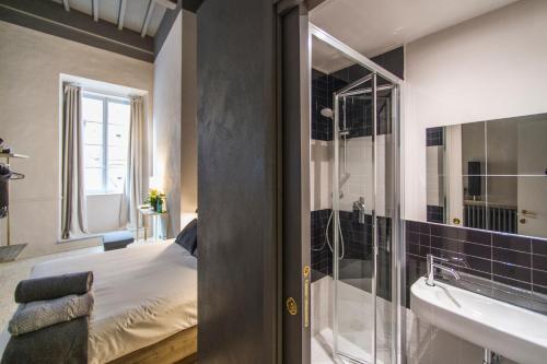 a bathroom with a bed and a shower and a sink at Palazzo del Papa in Siena