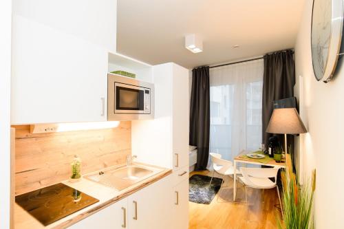 uma pequena cozinha com um lavatório e uma secretária em Aparthotel my room - Messe Munich em Munique