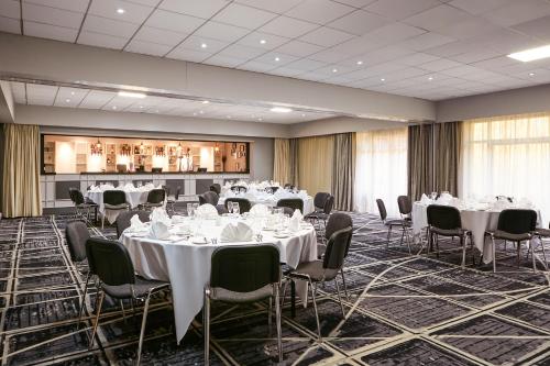 a banquet hall with white tables and chairs at Novotel Manchester West in Worsley