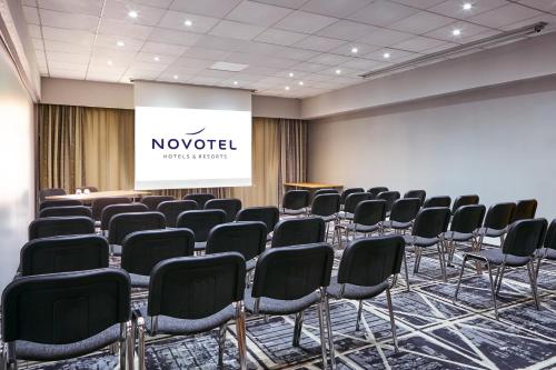 a conference room with chairs and a projection screen at Novotel Manchester West in Worsley