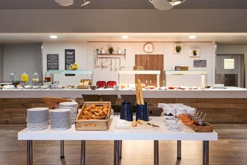 a table with plates and food on it in a kitchen at Novotel Manchester West in Worsley