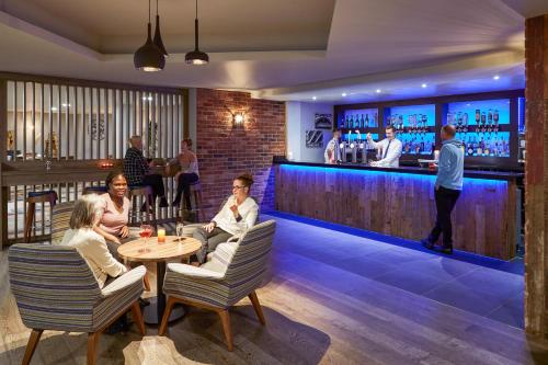 a group of people sitting at a bar at Novotel Manchester West in Worsley