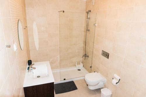 a bathroom with a toilet and a sink and a shower at Apartments Baleal: Sunshine by the Pool in Ferrel