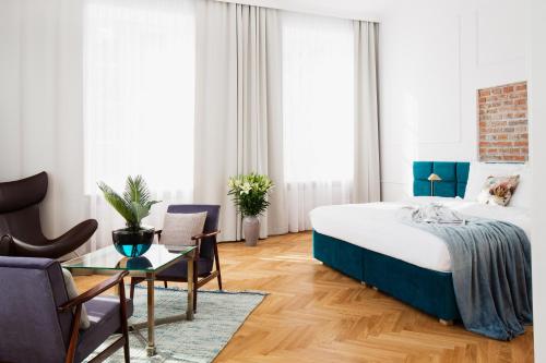 クラクフにあるSTRADOMSKA 2 APARTMENTSのベッド、テーブル、椅子が備わるホテルルームです。
