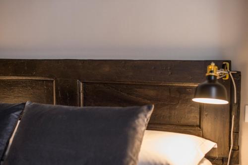a bed with a black headboard and a lamp at Palazzo del Papa in Siena