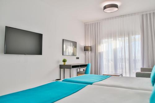 a hotel room with a bed and a television at Moon Hotel & SPA. in Aguadulce
