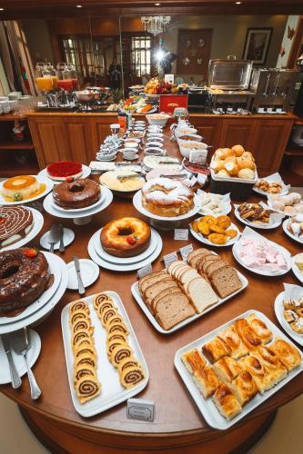 a long table filled with different types of pastries at Pousada Luis XV in Campos do Jordão