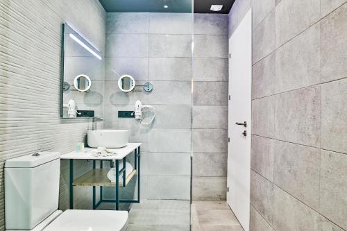 a bathroom with a toilet and a sink and mirror at Moon Hotel & SPA. in Aguadulce