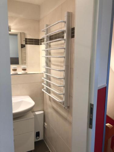 a white bathroom with a sink and a mirror at Ein kleines Haus in Fehmarn