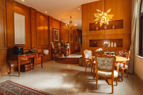 a dining room with a table and chairs and a chandelier at Pousada Luis XV in Campos do Jordão