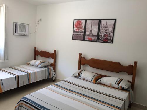 1 dormitorio con 2 camas y una foto en la pared en JP Palace Hotel, en Saquarema