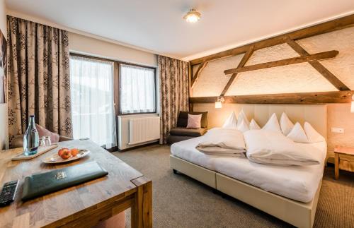 a hotel room with a bed and a desk at Alpen Villa Rieder in Filzmoos