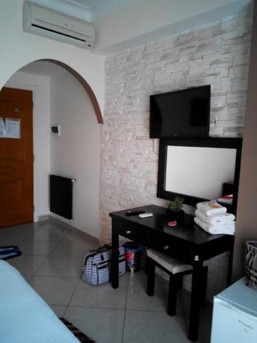 a bedroom with a desk with a tv on a brick wall at LES 2 HORLOGES in Oran