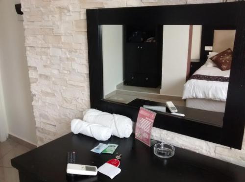a hotel room with a table and a mirror at LES 2 HORLOGES in Oran