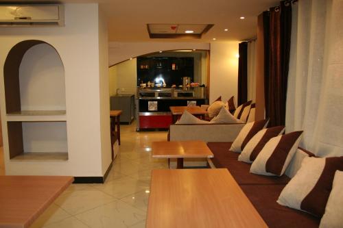 a living room with couches and tables and a kitchen at LES 2 HORLOGES in Oran