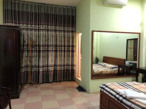 a bedroom with a mirror and a bed at Nhà nghỉ An Phú in Hanoi