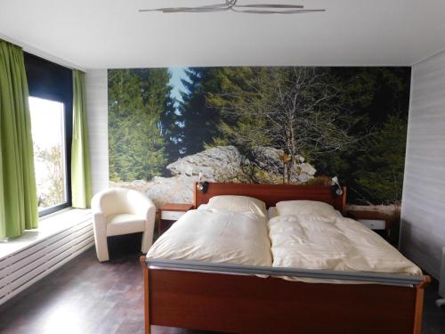 Pension Haus Petra في ألتيناو: غرفة نوم بسرير مع لوحة على الحائط