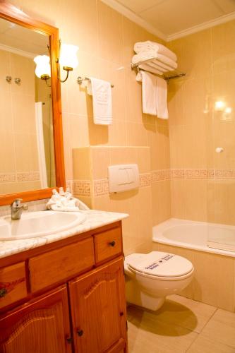 a bathroom with a sink and a toilet and a tub at Aparthotel Bahia Pinosol in Jávea