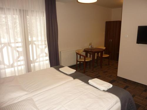 a hotel room with a bed and a table at Centrum Promocji Leśnictwa w Mucznem in Lutowiska