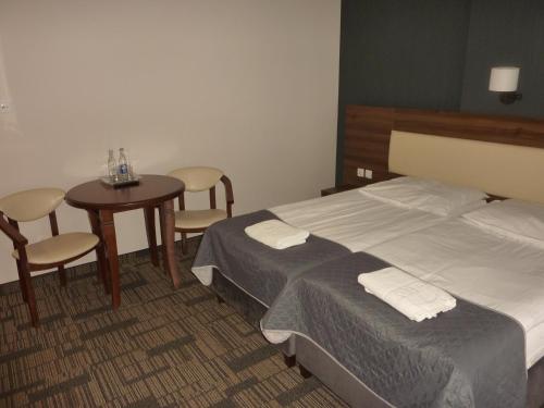 a hotel room with a bed and a table and chairs at Centrum Promocji Leśnictwa w Mucznem in Lutowiska