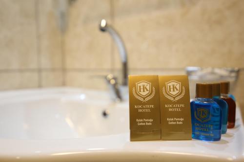 - un lavabo dans la salle de bains avec 2 bouteilles d'odorisants dans l'établissement kocatepe hotel, à Ankara