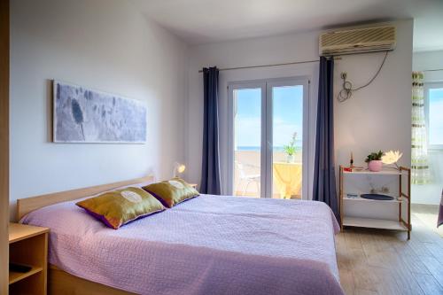 a bedroom with a bed and a large window at Guesthouse Ksenija in Komiža