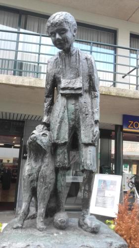 a statue of a boy with a dog in front of a building at Henriëtta in Hoboken