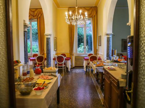 uma sala de jantar com mesas e cadeiras e um lustre em Hotel Delle Rose em Rapallo