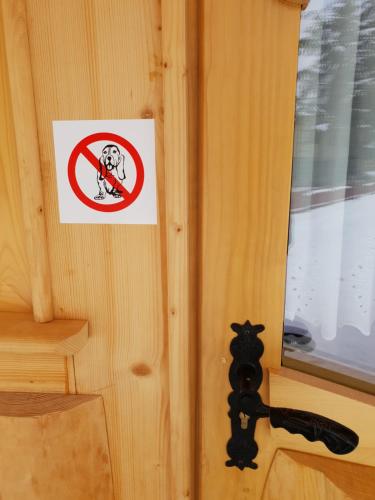 a sign on a door with a gun on it at Domki u Magdy in Zakopane