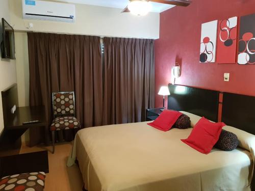 a bedroom with a large bed with red walls at Hotel Trocadero in Necochea