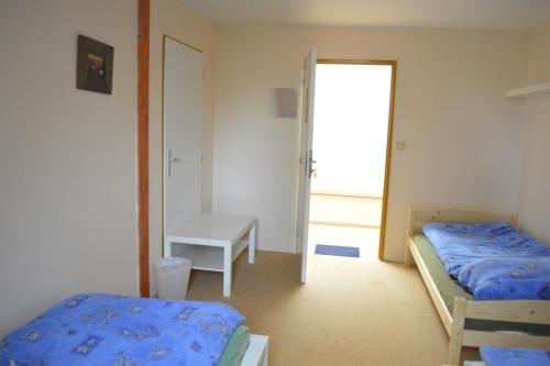 a bedroom with two beds and a table and a window at Stará Fara in Chržín
