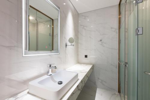 a white bathroom with a sink and a mirror at N Bridge Hotel JEON JU in Jeonju