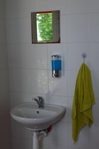 a bathroom with a sink and a green towel at Stará Fara in Chržín