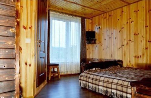 a bedroom with a bed in a room with a window at Hotel Dudarik in Kosiv