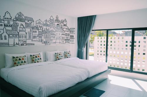 a bedroom with a large bed with a city mural on the wall at Wannachart Boutique Resort in Tha Sala