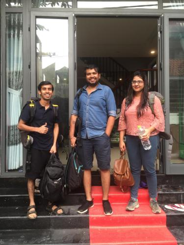 a group of three people standing on a red carpet at candyinn in Hue