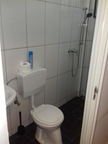 a small bathroom with a toilet and a shower at Waterland Suites in Paramaribo