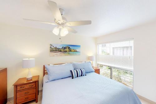 a bedroom with a bed and a ceiling fan at Sandpiper #116b in Princeville